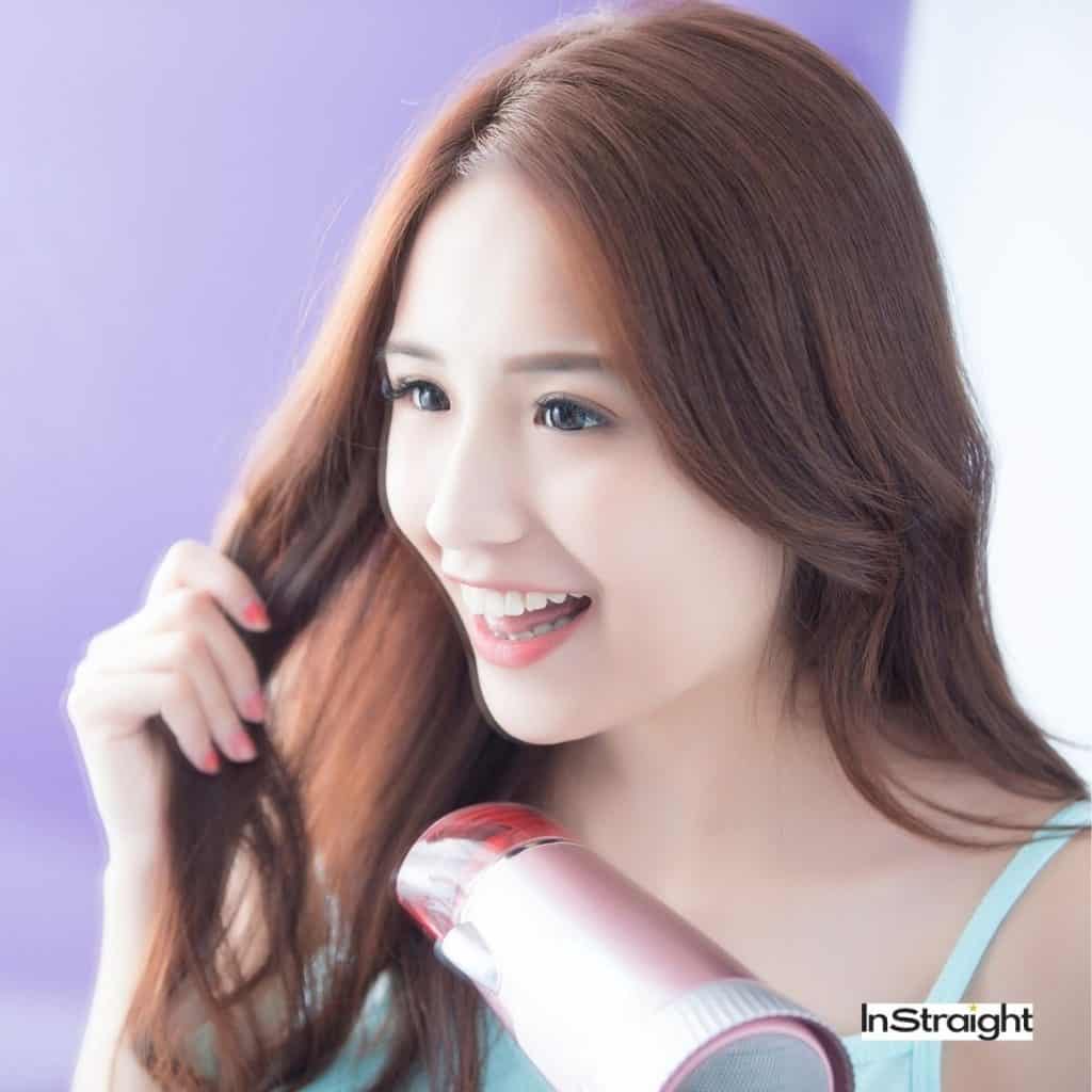 pretty lady showing her techniques on how to blow dry thin hair for volume